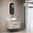 Bathroom vanity with wooden cabinet, round mirror, and light fixture.