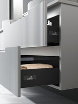 Modern kitchen cabinet with open drawer displaying Hettich branding.