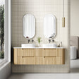 Bathroom with wooden vanity, double sinks, and two mirrors.