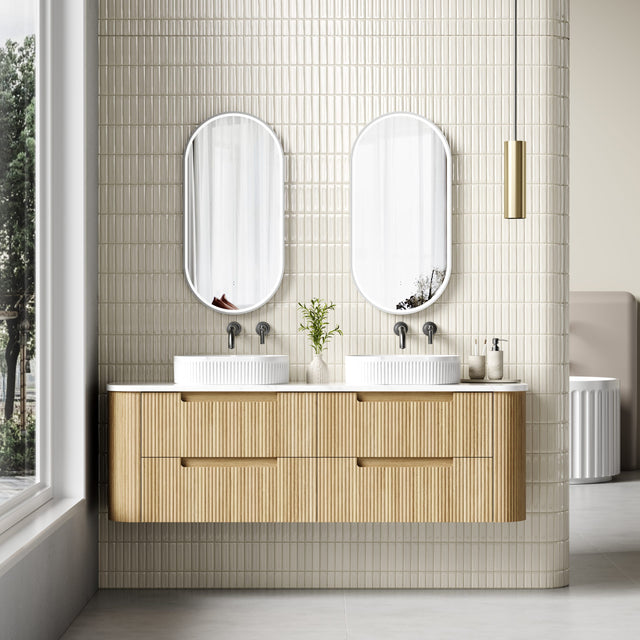 Bathroom with wooden vanity, double sinks, and two mirrors.