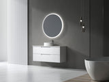 Modern bathroom with a round illuminated mirror and white vanity.
