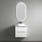 Bathroom vanity with illuminated oval mirror against a gray wall