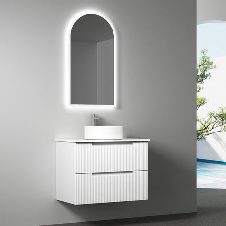 Bathroom vanity with sink and illuminated mirror against a gray wall.