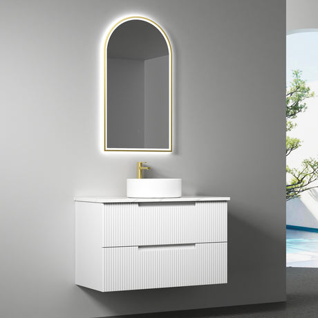 Bathroom vanity with illuminated mirror and sink against a gray wall.