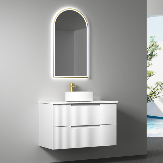 Bathroom vanity with illuminated mirror and sink against a gray wall.