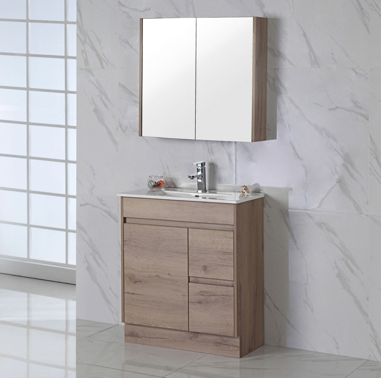 Bathroom vanity with right hand drawer with mirror cabinet against a marble wall.