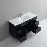 Bathroom vanity with white sink and open drawer against a gray wall.