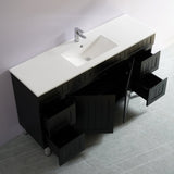 Bathroom vanity with white countertop and black cabinets against a gray wall.