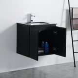 Black bathroom vanity with open cabinet door showing toiletries against a white wall.