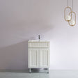 White bathroom vanity with sink against a white wall with modern pendant lights.