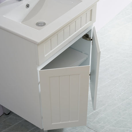 White bathroom vanity with sink and open cabinet door on a tiled floor.