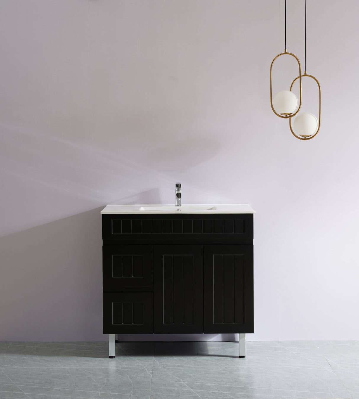Black bathroom vanity with white countertop against a plain wall with gold pendant lights.