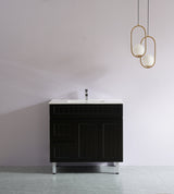 Black bathroom vanity with white countertop against a plain wall with gold pendant lights.