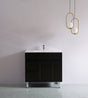Black bathroom vanity with white countertop against a plain wall with gold pendant lights.