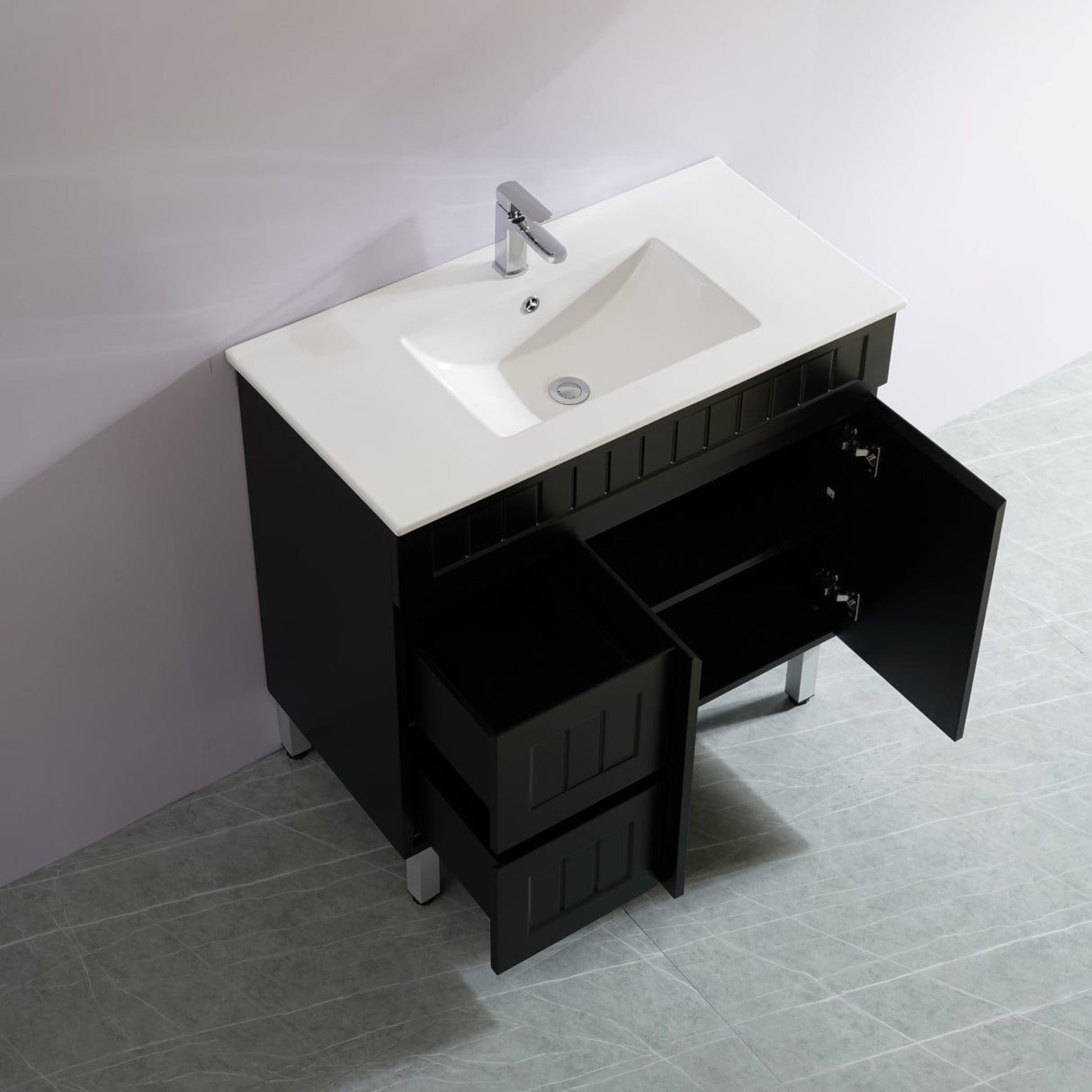 Bathroom vanity with white sink and open black cabinet door.