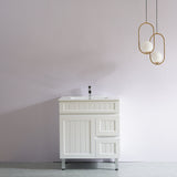 White bathroom vanity with a sink against a plain wall with modern pendant lights.