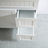 White bathroom vanity with open drawer on a tiled floor