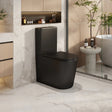 Modern black toilet in a stylish bathroom with marble walls and a bathtub.