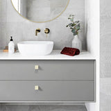 Bathroom vanity with round mirror, sink, and decorative elements.