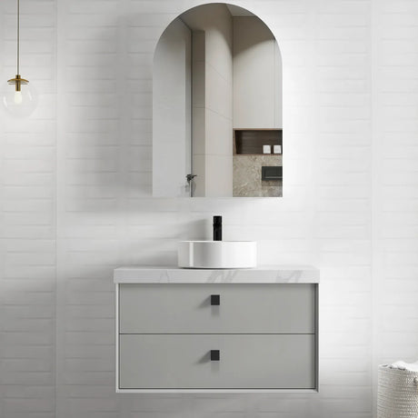 Bathroom vanity with marble countertop and arch-shaped mirror