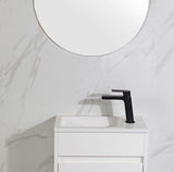 Bathroom vanity with black faucet and round mirror on white marble wall