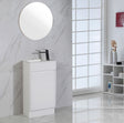 Bathroom vanity with round mirror and black faucet against a marble wall.