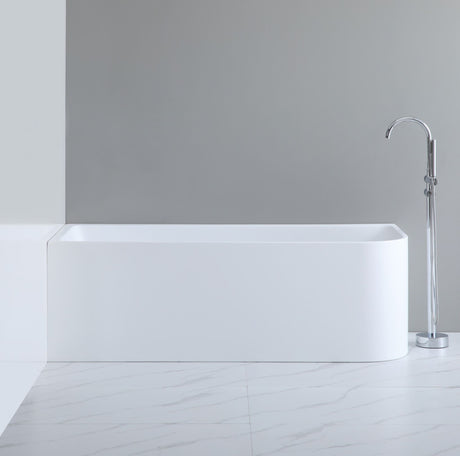 White freestanding bathtub with a silver faucet against a gray wall.