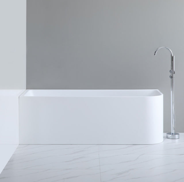 White freestanding bathtub with a silver faucet against a gray wall.