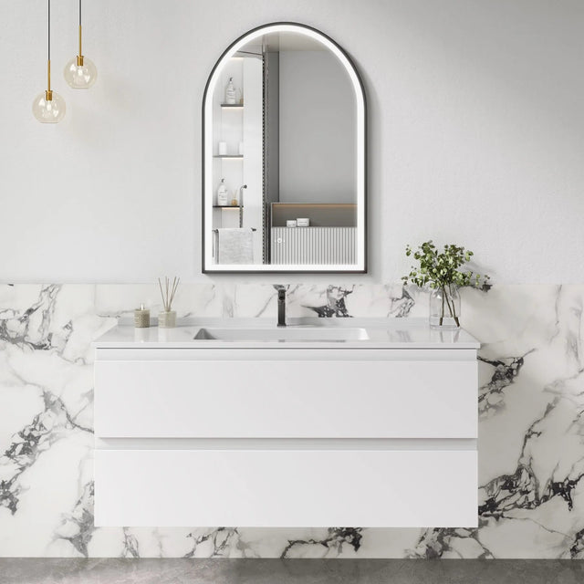 Bathroom vanity with marble wall and arch mirror