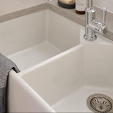 White kitchen sink with silver faucet, soap bottle, and bar of soap.