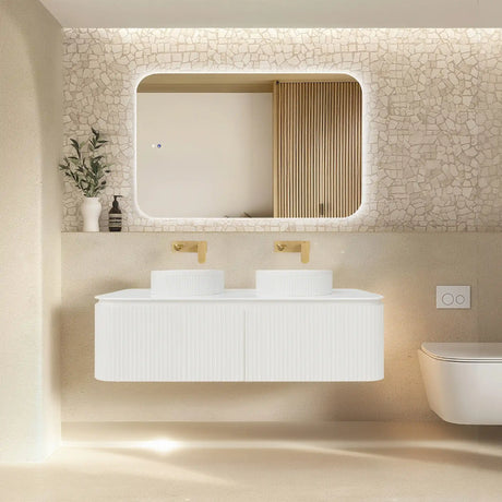 Modern bathroom with a white vanity, mirror, and decorative elements.