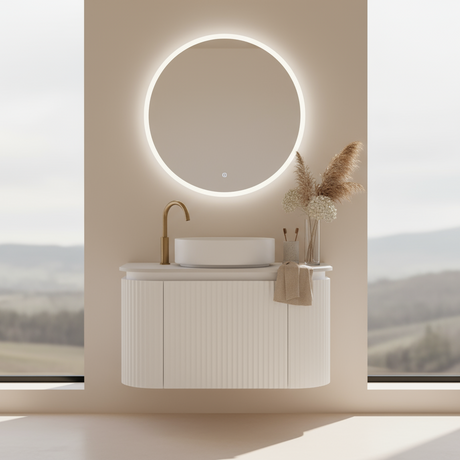 Bathroom vanity with round mirror and decorative elements against a scenic window backdrop