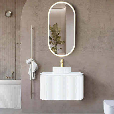Bathroom with a white vanity, mirror, and plant on a brown wall.