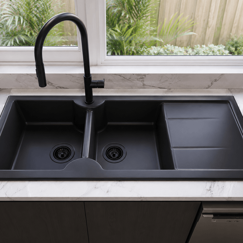 Black kitchen sink with a modern faucet in a well-lit kitchen.