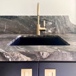 Marble countertop with a sink and gold faucet
