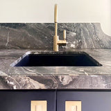 Marble countertop with a sink and gold faucet