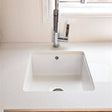 White kitchen sink with silver faucet in a modern kitchen setting