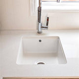 White kitchen sink with silver faucet in a modern kitchen setting