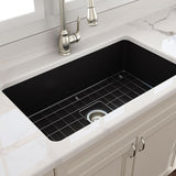 Black farmhouse kitchen sink with silver faucet in a modern kitchen setting.