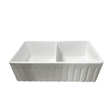 A white ceramic double-bowl sink with a ribbed exterior, shown from a front-three-quarters angle on a solid white background.
