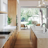 Modern kitchen with wooden cabinets, white countertops, and a large window.