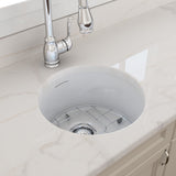 White kitchen sink with silver faucet on a marble countertop