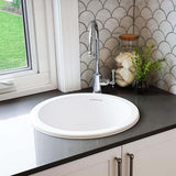 Bathroom sink with faucet against a tiled wall
