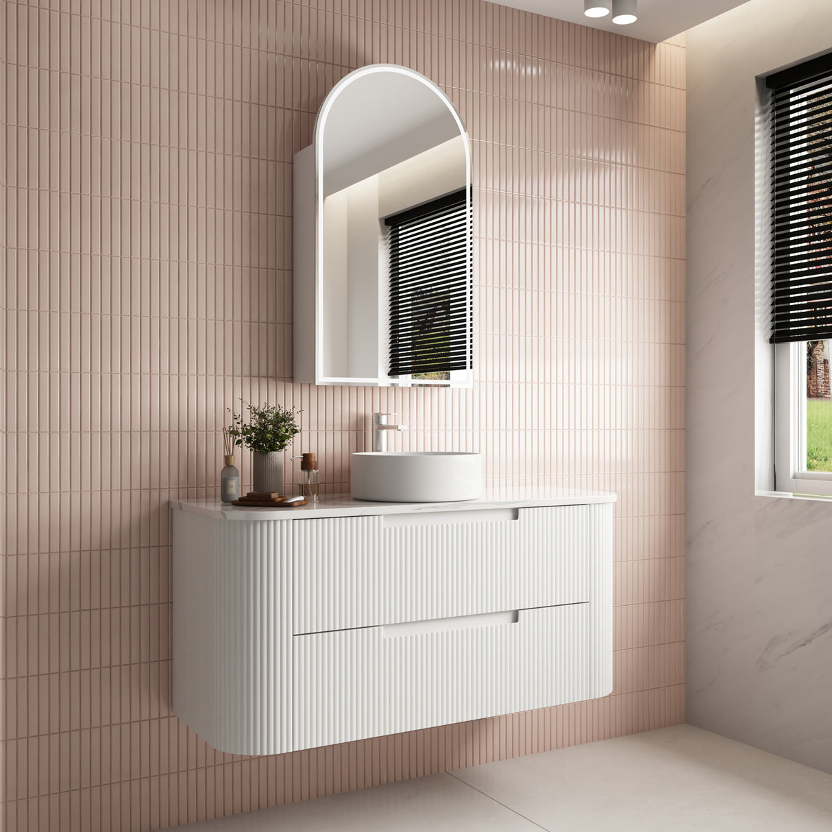 Bathroom vanity with sink and mirror against a tiled wall.