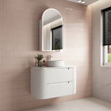 Bathroom vanity with sink and mirror against a tiled wall.