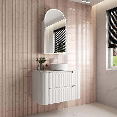 Bathroom vanity with sink and mirror against a tiled wall.