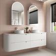 Bathroom vanity with two sinks and mirrors in a tiled bathroom.