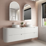 Bathroom vanity with two sinks and mirrors in a tiled bathroom.