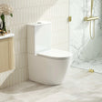 Modern white toilet in a bathroom with marble walls and a shower area.