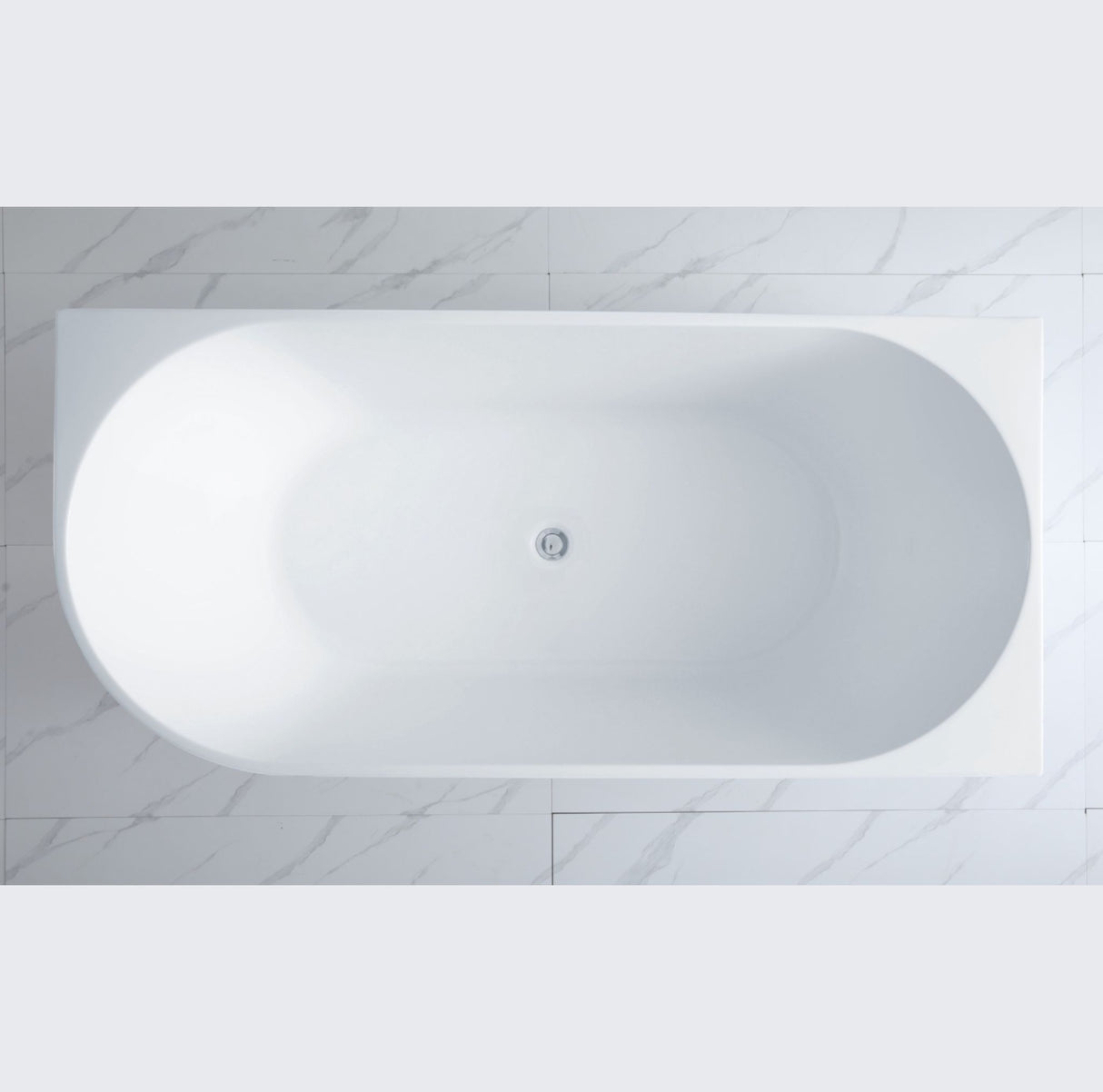 White oval bathtub in a bathroom with marble tiles
